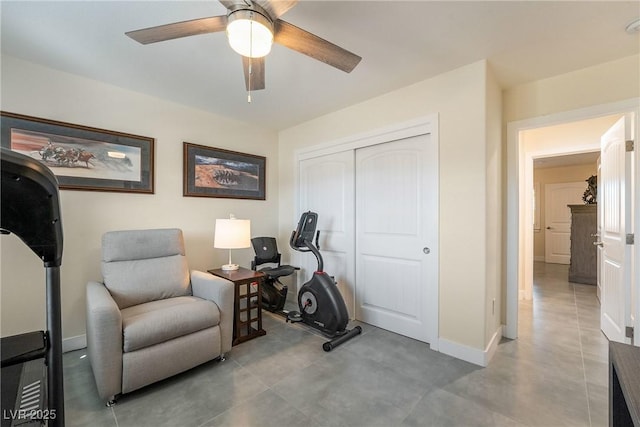 workout room with baseboards and ceiling fan