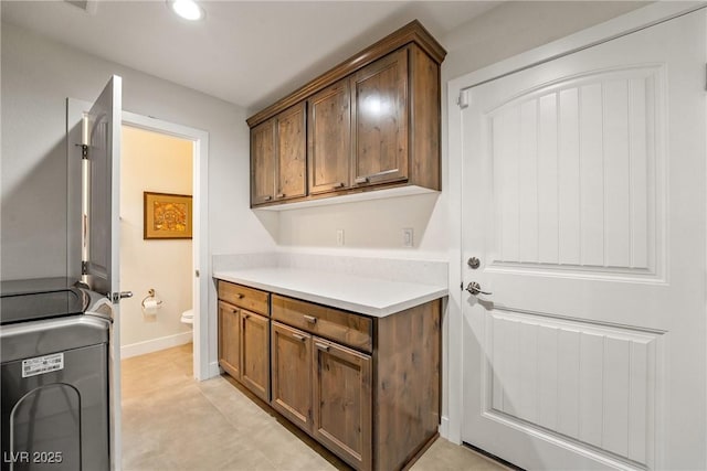 washroom with washer / dryer, recessed lighting, cabinet space, and baseboards