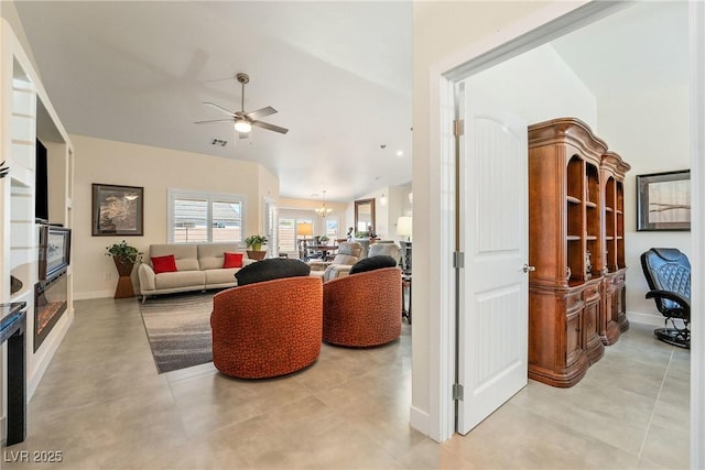 living room featuring visible vents, baseboards, and ceiling fan with notable chandelier