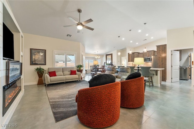 living area featuring a glass covered fireplace, recessed lighting, visible vents, and high vaulted ceiling