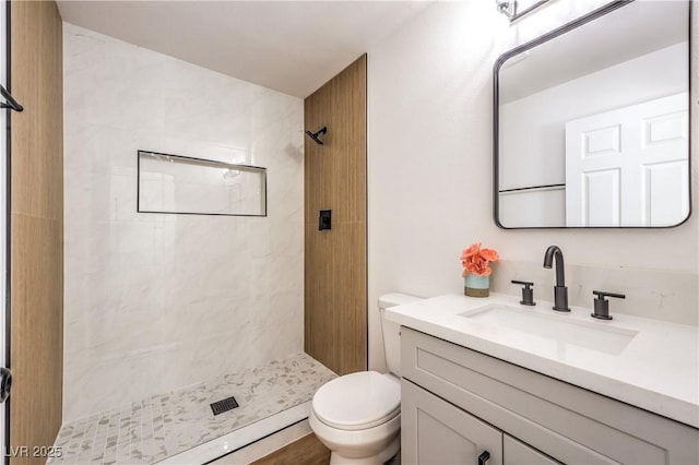 full bath featuring a stall shower, toilet, and vanity