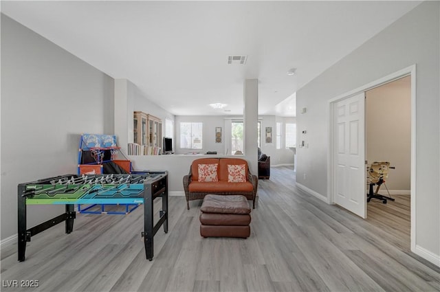 interior space featuring light wood-style floors, visible vents, and baseboards