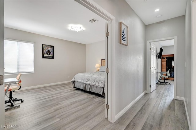 bedroom featuring visible vents, light wood-type flooring, and baseboards