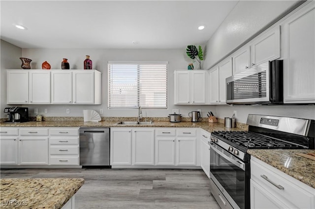 kitchen with white cabinetry, appliances with stainless steel finishes, and a sink