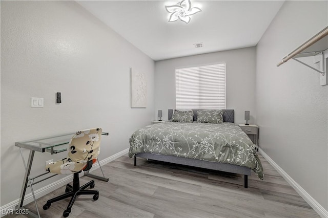 bedroom featuring visible vents, wood finished floors, and baseboards