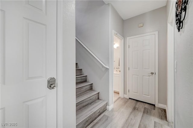 staircase with baseboards and wood finished floors