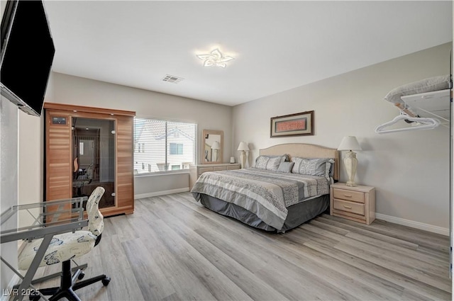 bedroom featuring visible vents, baseboards, and light wood-style flooring