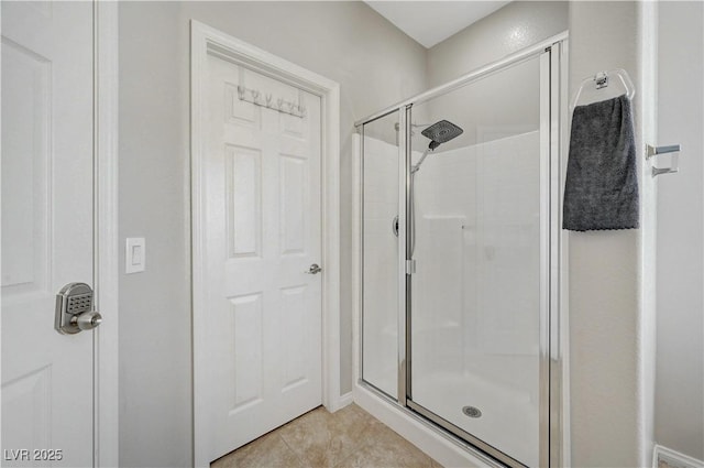 bathroom featuring tile patterned flooring and a shower stall