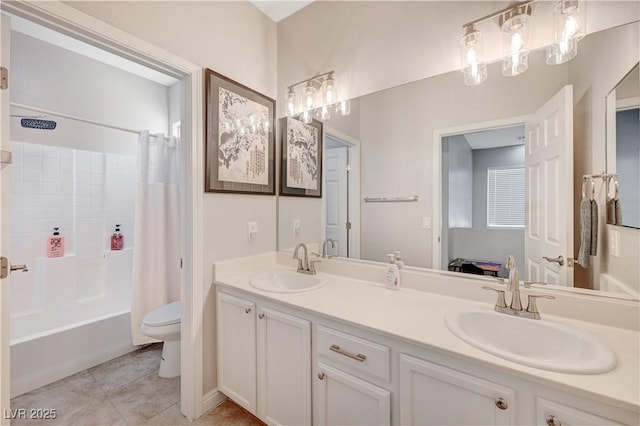 bathroom featuring double vanity, toilet, and a sink