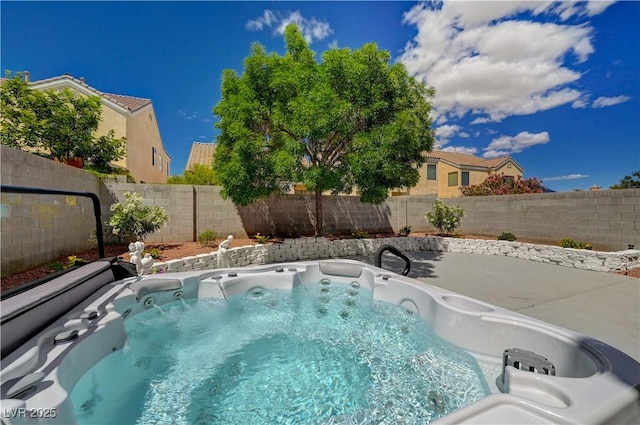 view of pool with a fenced backyard and a hot tub