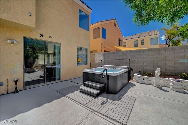 view of patio / terrace featuring fence and a hot tub