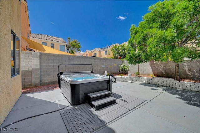 view of patio / terrace with a fenced backyard and a hot tub