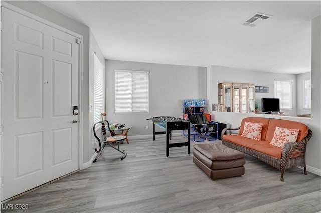 living room with visible vents, baseboards, and wood finished floors