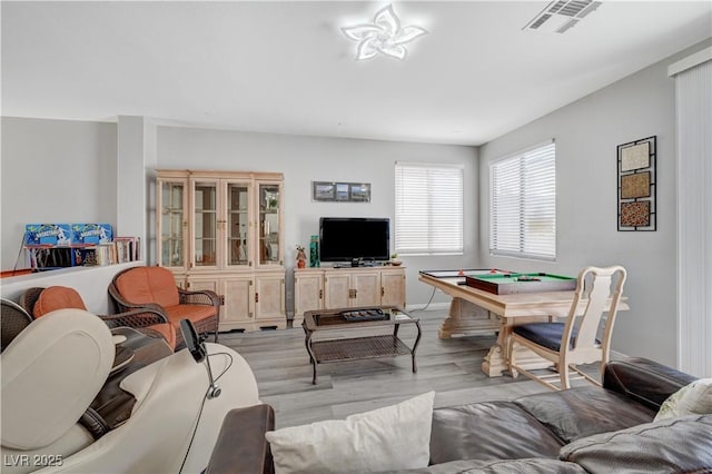 living area with visible vents and light wood-style floors