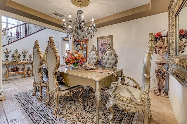 dining space with a raised ceiling, a notable chandelier, baseboards, and visible vents