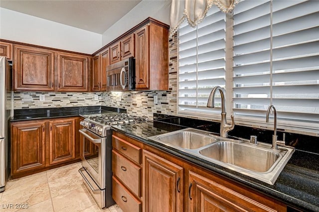 kitchen with a sink, backsplash, appliances with stainless steel finishes, and brown cabinetry