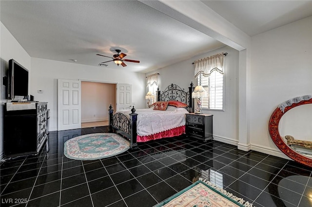 bedroom featuring dark tile patterned floors, baseboards, and ceiling fan