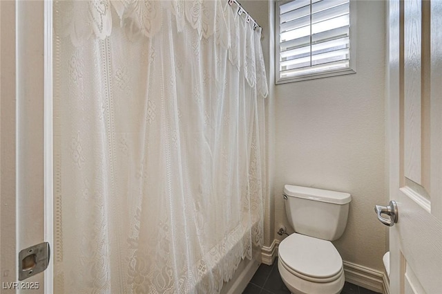 bathroom with tile patterned floors, baseboards, and toilet