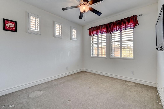 empty room with carpet flooring, ceiling fan, and baseboards