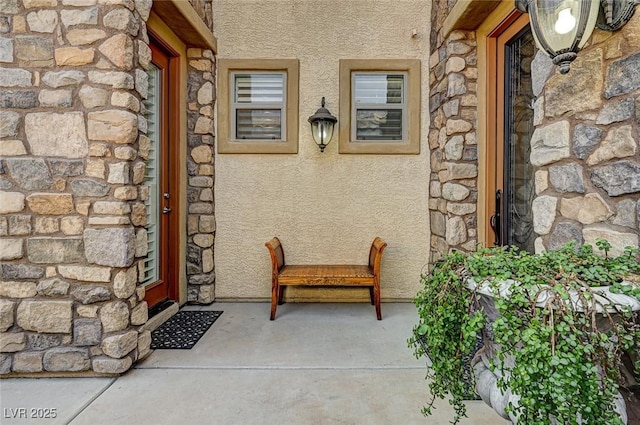 entrance to property with stucco siding and stone siding