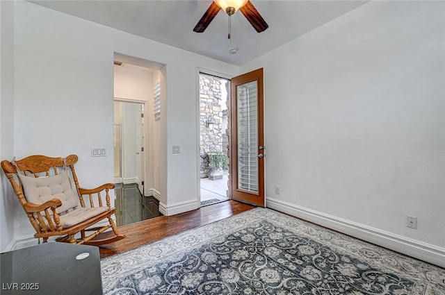 foyer featuring ceiling fan, baseboards, and wood finished floors