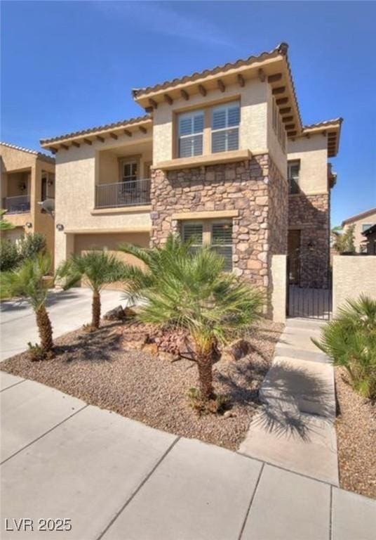 view of front of house with stone siding, stucco siding, concrete driveway, and a balcony