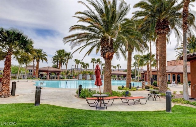 community pool with a lawn and a patio area