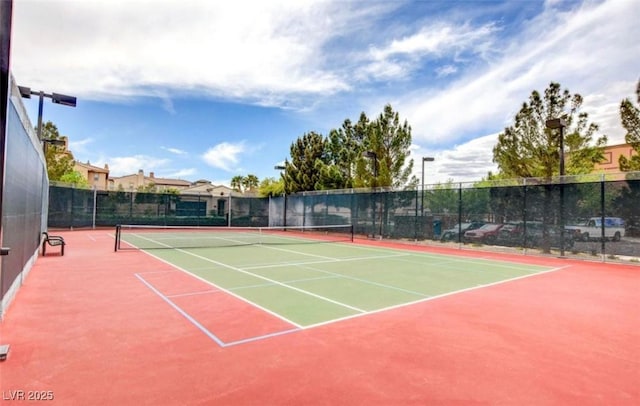 view of tennis court with community basketball court and fence