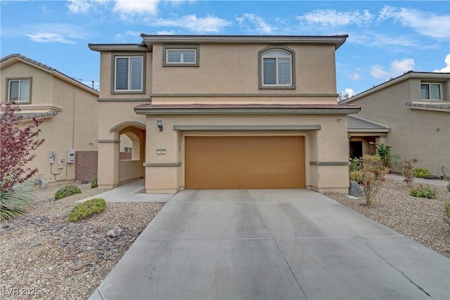 traditional home featuring concrete driveway, an attached garage, and stucco siding