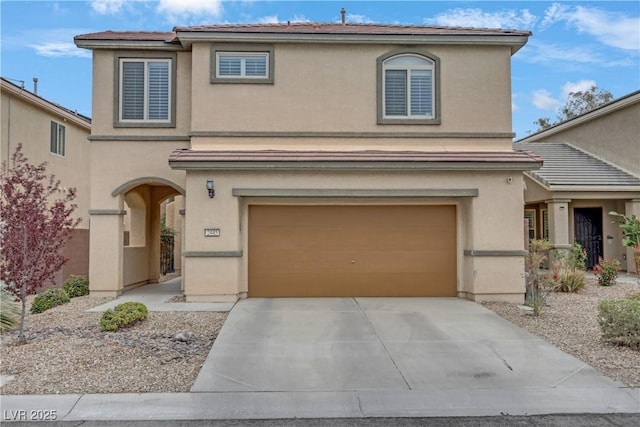 traditional-style house featuring stucco siding, an attached garage, and driveway