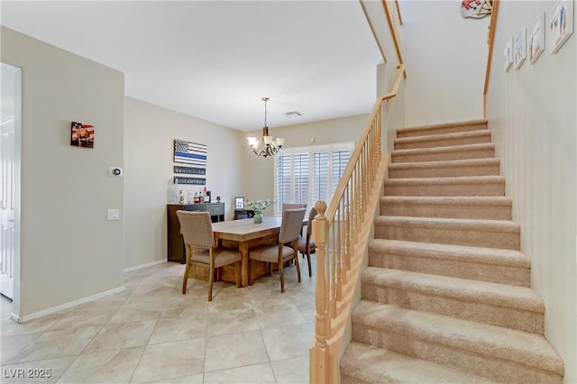 dining area with visible vents, a notable chandelier, light tile patterned floors, baseboards, and stairs