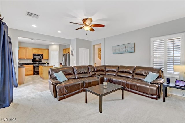 living area featuring a ceiling fan, recessed lighting, light colored carpet, and visible vents