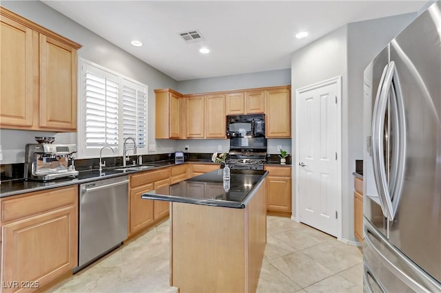 kitchen featuring visible vents, light brown cabinetry, dark countertops, a center island, and appliances with stainless steel finishes