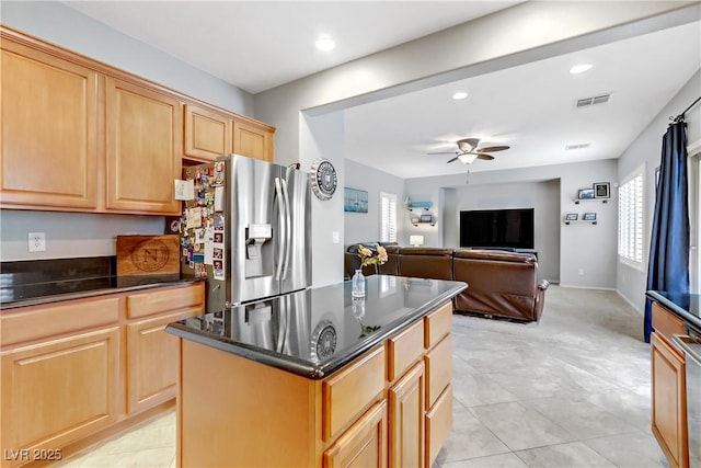 kitchen featuring visible vents, light brown cabinets, a ceiling fan, a kitchen island, and stainless steel fridge