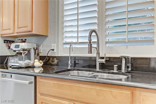 kitchen featuring light brown cabinetry, dishwasher, and a sink