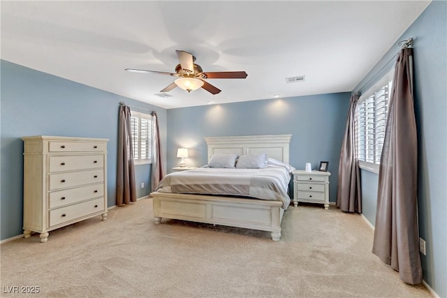 bedroom featuring light carpet, visible vents, baseboards, and ceiling fan