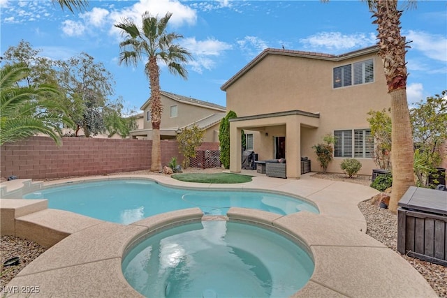 view of swimming pool featuring fence, a pool with connected hot tub, and a patio area