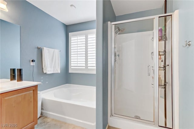 bathroom featuring vanity, a garden tub, and a stall shower