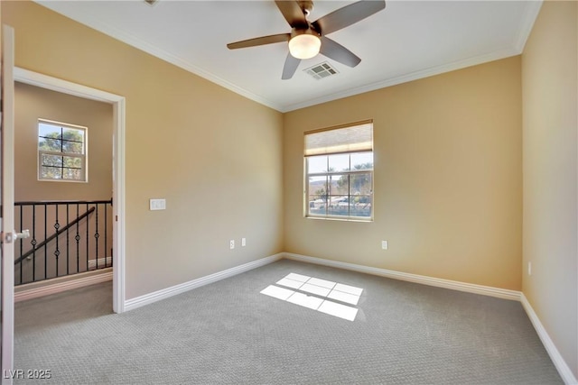 spare room featuring visible vents, ornamental molding, carpet flooring, baseboards, and ceiling fan