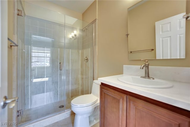 bathroom with vanity, toilet, and a stall shower