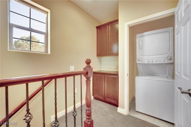 laundry room with laundry area, stacked washer and dryer, and light carpet