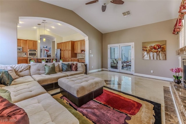 living room featuring visible vents, lofted ceiling, arched walkways, and baseboards