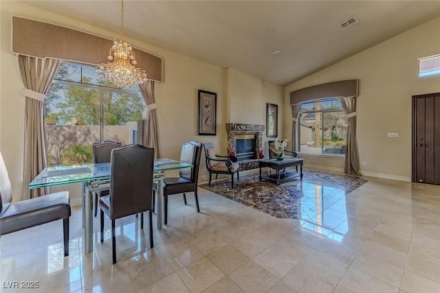 dining room featuring a wealth of natural light, visible vents, a notable chandelier, and a glass covered fireplace