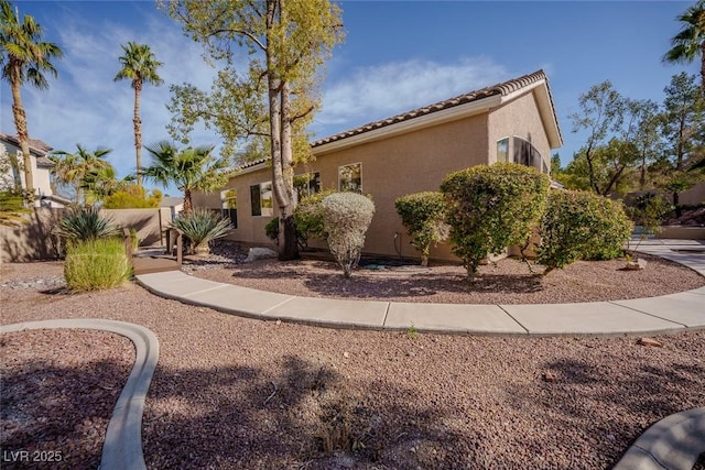 view of property exterior featuring a tiled roof and stucco siding