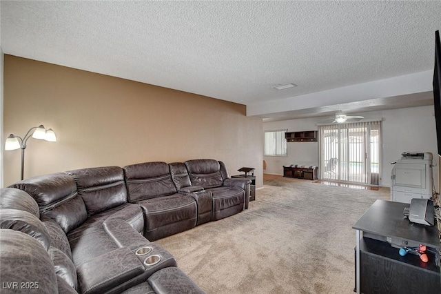 living room with carpet, a ceiling fan, and a textured ceiling