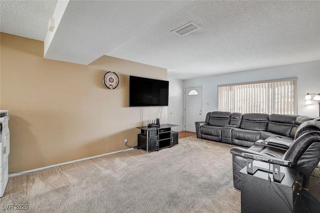 carpeted living area featuring visible vents and a textured ceiling