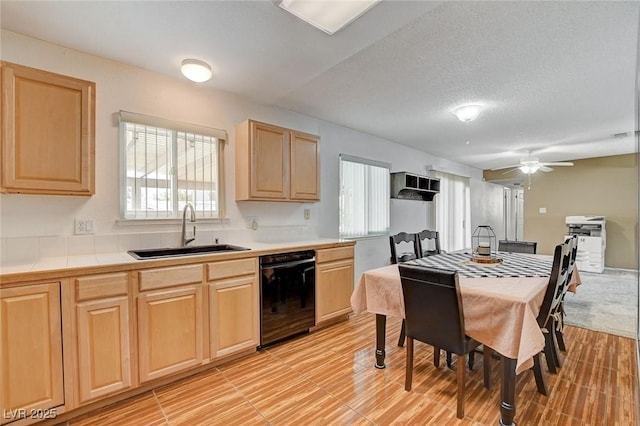 kitchen with light brown cabinetry, a sink, black dishwasher, a textured ceiling, and ceiling fan