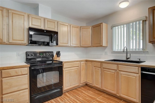 kitchen featuring a sink, tile countertops, black appliances, and light brown cabinets