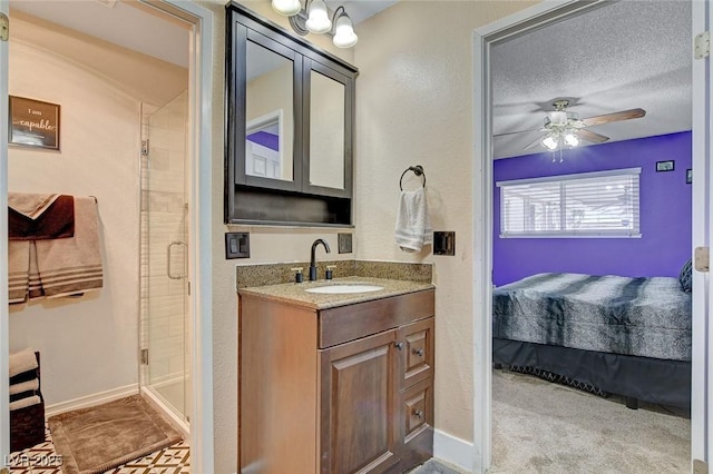 ensuite bathroom with a shower stall, ensuite bathroom, a textured ceiling, vanity, and a ceiling fan