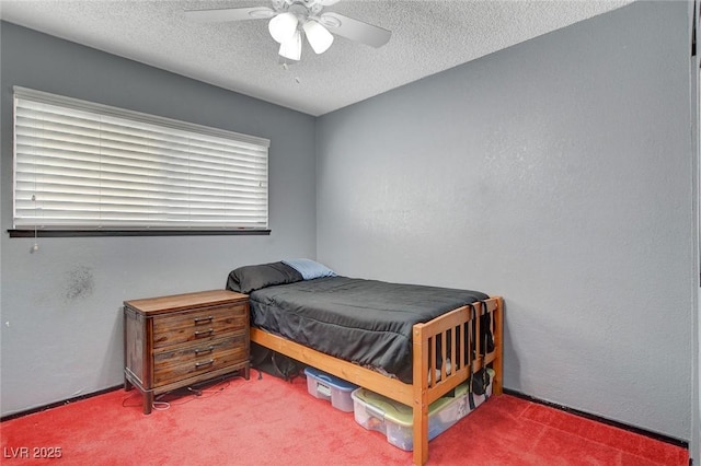 carpeted bedroom with a textured ceiling, ceiling fan, and a textured wall